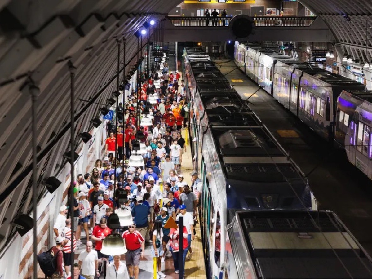 A crowded Sound Transit light rail platform after an event, riders filling the platform beside two trains.